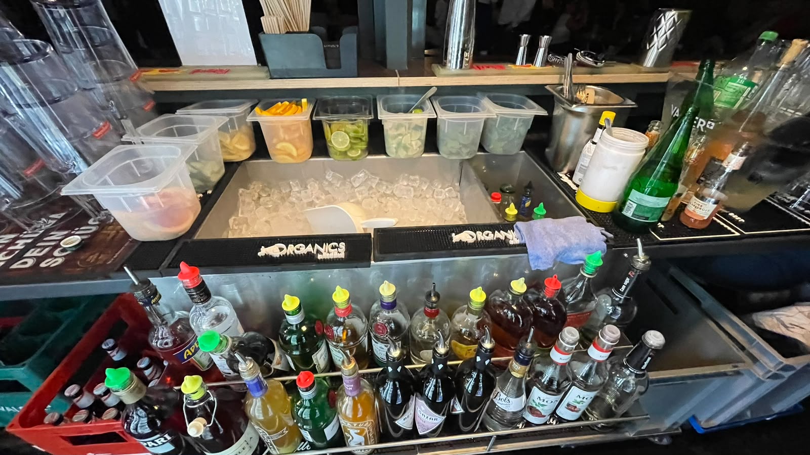 Arbeitsplatz an einer Bar mit vorbereiteten Zutaten und Flaschen