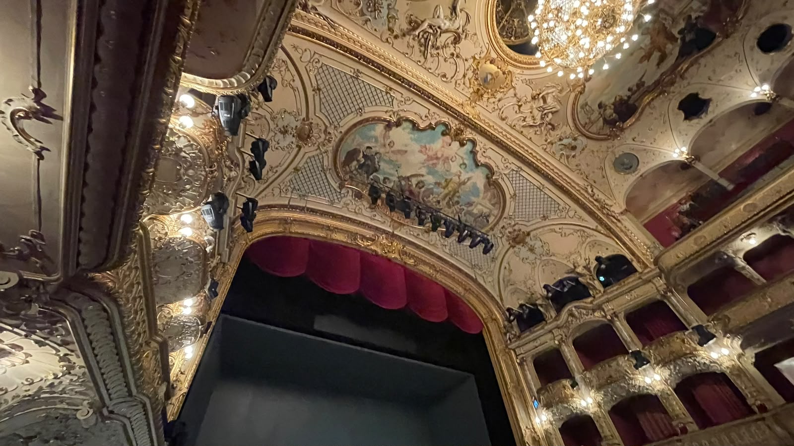 Blick auf Bühne, Logen und verzierte Decke eines Opernsaals